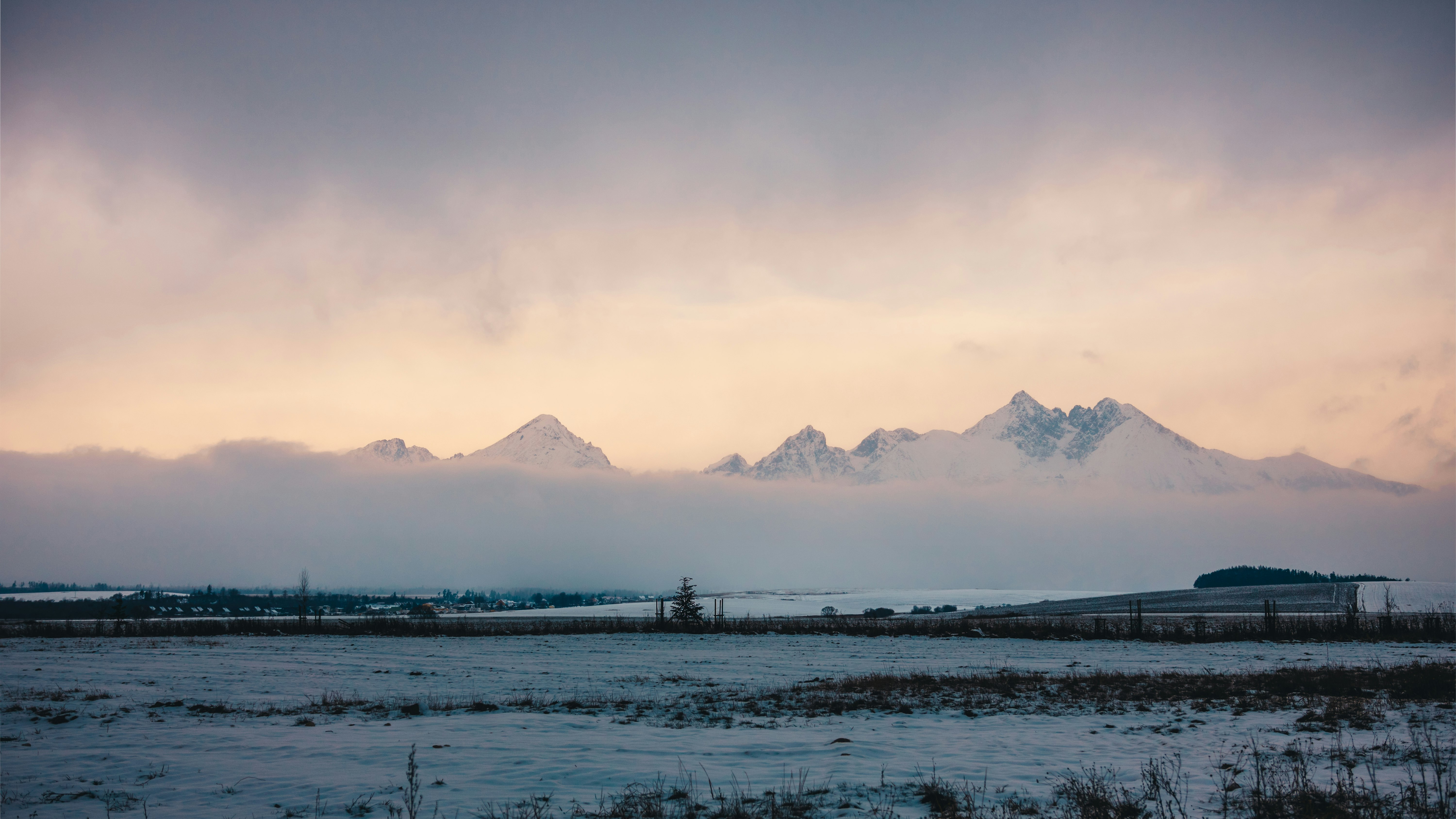 mountain near body of water under cloudy sky